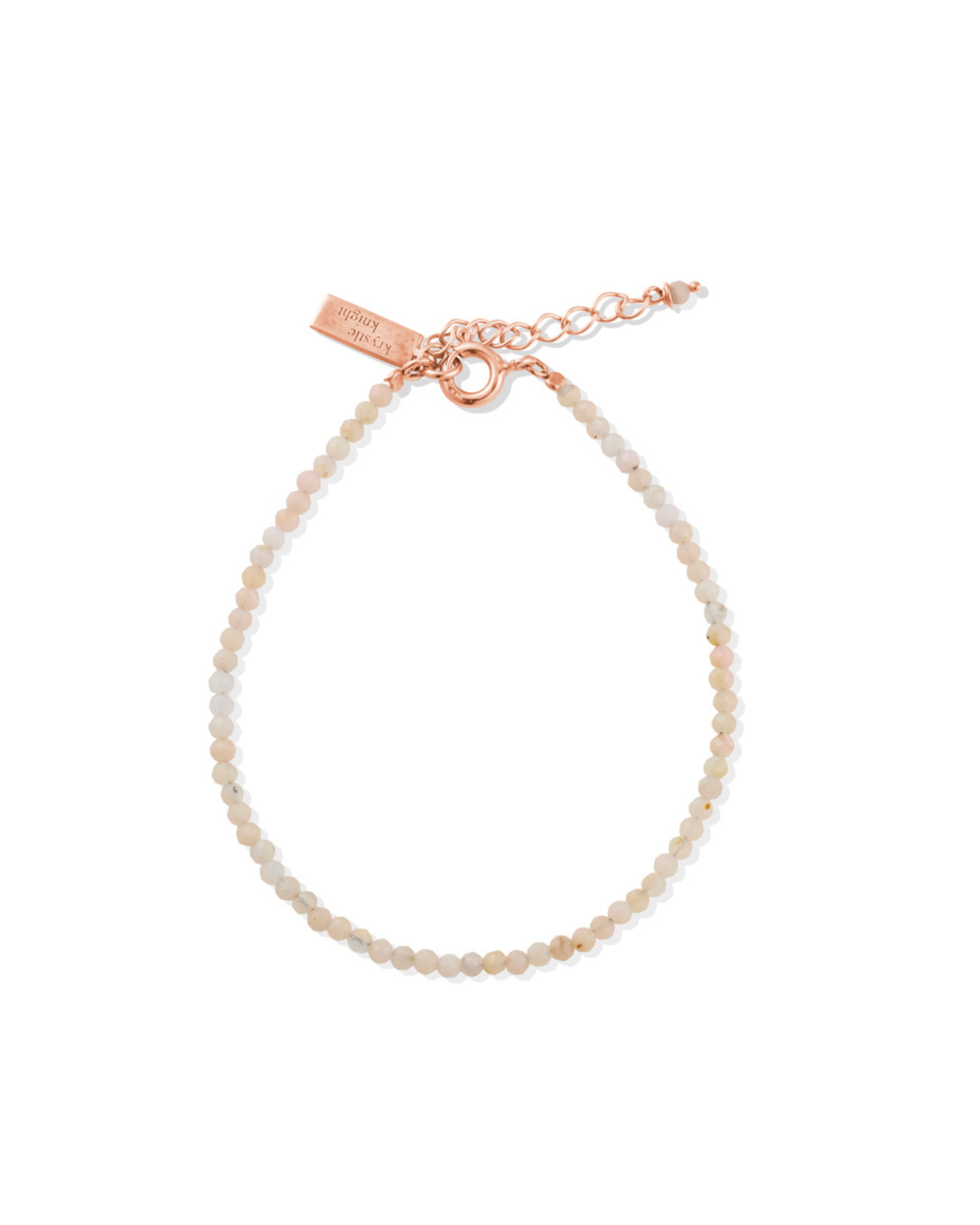 Rose gold Pink Opal bracelet with a tag on a white background