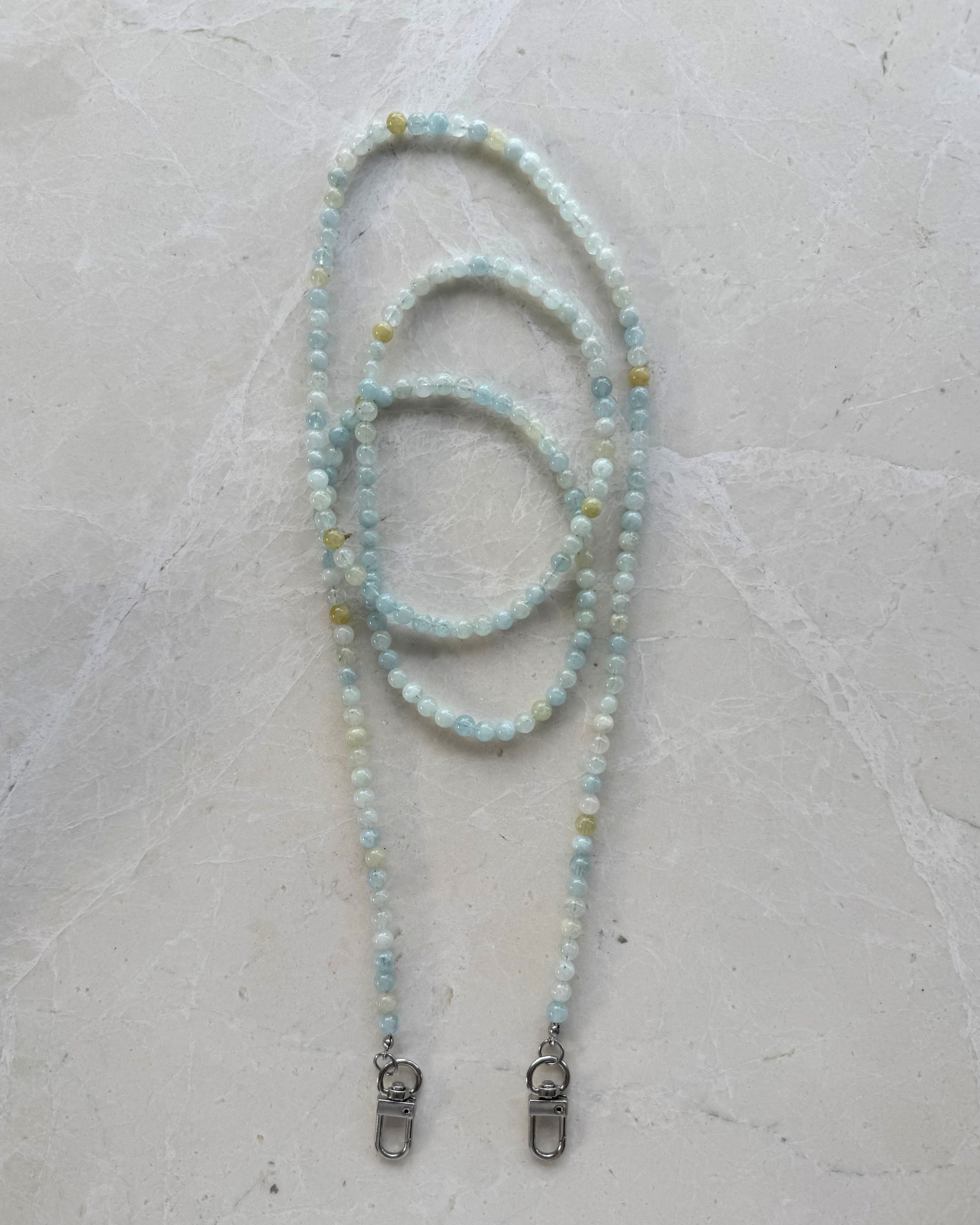 Aqua Marine Beaded Phone Carrier with metal clasps on a light grey background