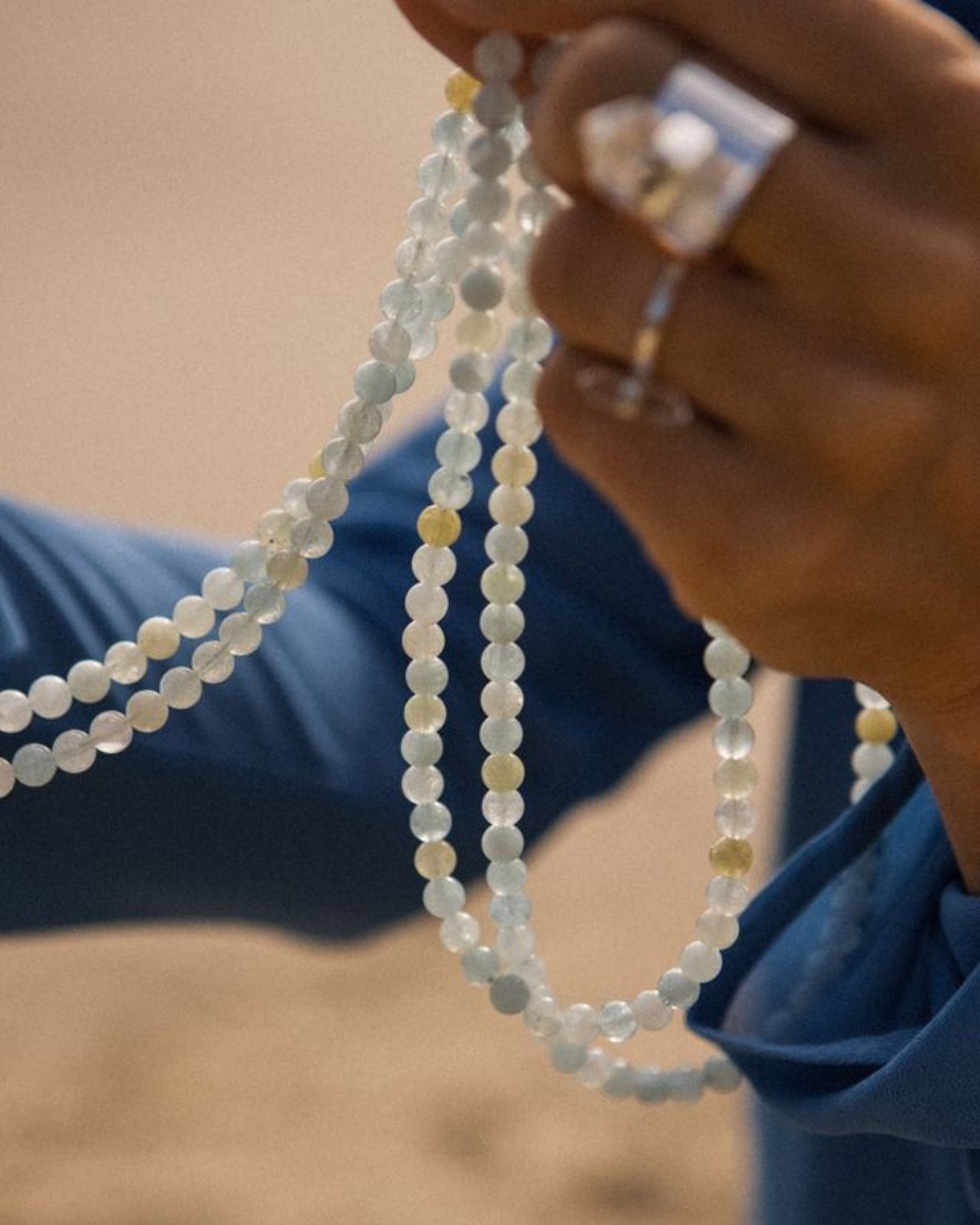 Close-up of a hand holding beaded carrier against a blurred background